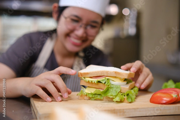 Obraz Chef with a eggs sandwich ready for plating