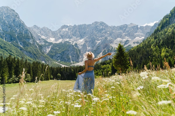 Obraz Woman in nature in blooming alps meadow in mountains.