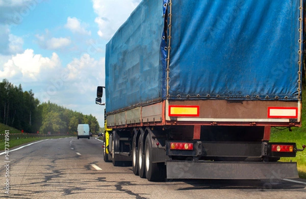 Fototapeta Transportation of consolidated cargo for online stores by trucks with semi-trailers along the highway in the summer. Insurance of cargo and vehicles of transport companies. Copy space for text