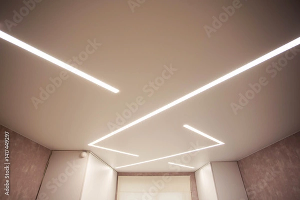 Fototapeta Modern designer stretch ceiling with illuminated LED lines in the room, backlighting