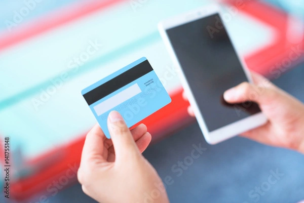 Obraz People using credit card and smart phone paying online.