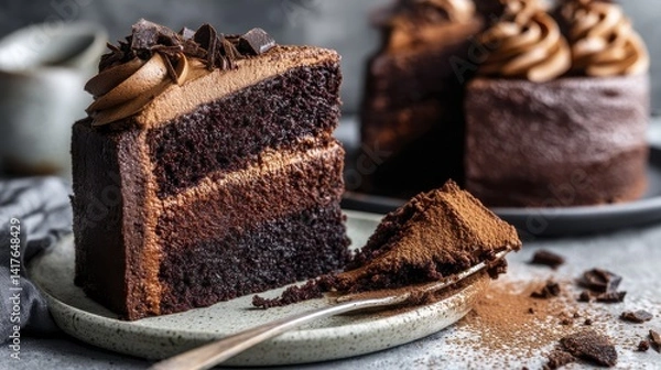 Fototapeta Moist chocolate cake with swirls of creamy chocolate frosting, dusted with cocoa powder - chocolate cake swirls soft