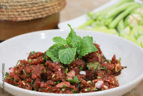 Fototapeta Raw beef Issan salad made from beef, herbs and blood Larb Luad, Raw Beef Larb With liver and blood in a plate ready to serve. Thai food. Spicy and delicious, Thai traditional food. Raw minced meat.