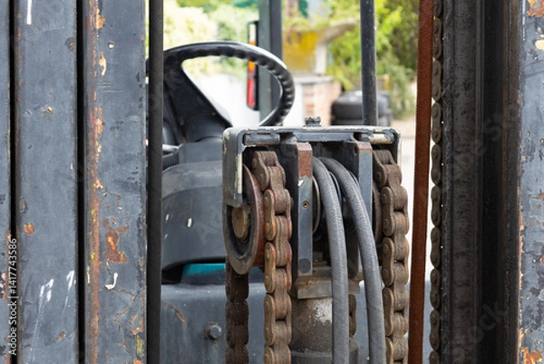 Obraz Rusty chains and hydraulic hoses operating lift mechanism on forklift truck