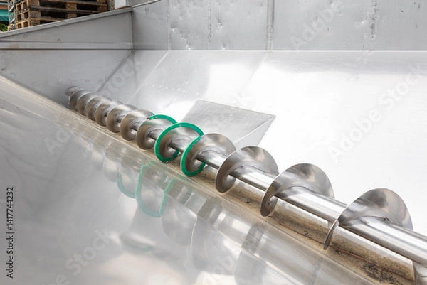 Fototapeta Industrial auger conveyor system transporting materials in modern factory