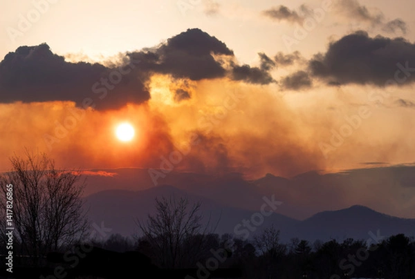 Fototapeta Smoke from a forest fire at sunset in the Appalachian Mountains in Polk County, North Carolina in 2025. 