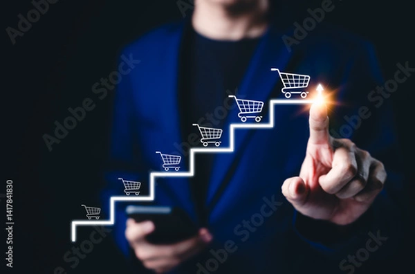 Obraz E-commerce growth and online sales strategy development. Businessman pointing to arrow with shopping cart icons, online sales growth, digital marketing success, performance optimization for business,