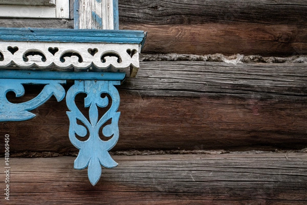 Obraz Detail of ornate window frame. Corner of decorative window frame. Details of window framing of log house close-up. Window on wall framed with carved elements in white and blue.