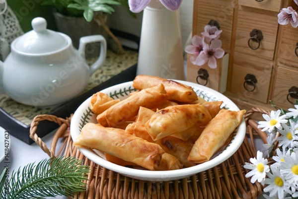 Fototapeta Fried spring rolls or Popiah Goreng, crispy fried spring roll filled with vegetables, meat or prawns, offering a crunchy delight.  Usually served for breakfast or afternoon tea.