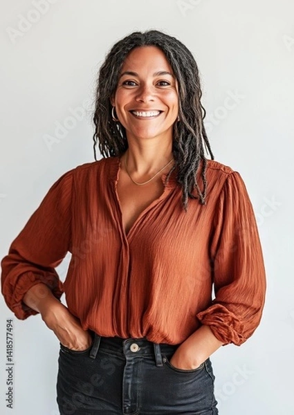 Fototapeta Portrait of a smiling Black woman with braided hairstyle in rust blouse and jeans, isolated on white background, confident young female looking at camera for diversity or lifestyle concept 