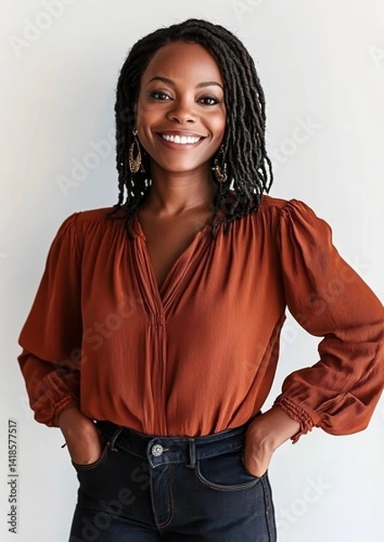 Fototapeta Portrait of a smiling Black woman with braided hairstyle in rust blouse and jeans, isolated on white background, confident young female looking at camera for diversity or lifestyle concept 