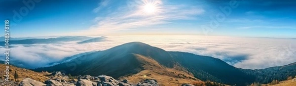 Fototapeta Panoramic view of Carpathian Mountains with foggy valley and sunlight on mountain peak under vibrant blue sky with clouds, wide high-resolution morning landscape background