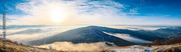 Fototapeta Panoramic view of Carpathian Mountains with foggy valley and sunlight on mountain peak under vibrant blue sky with clouds, wide high-resolution morning landscape background