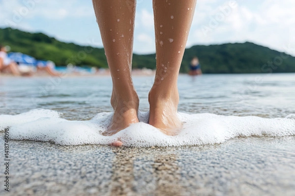 Obraz Grainy toes sinking into beach sand, shallow water curling close with foamy edge visible