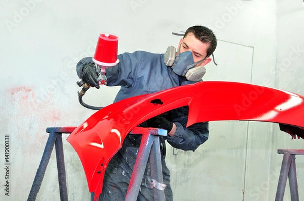Obraz Worker painting red car bumper.