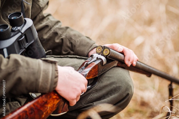 Fototapeta myśliwy ładowanie karabinu w zimowym lesie. Koncepcja Bushcraft, łowiectwo i ludzie