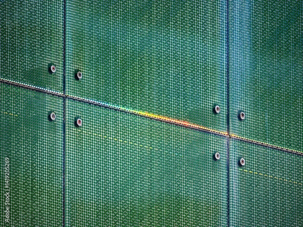 Obraz Close-up of a green metal mesh wall with bolts and a diagonal rust line.