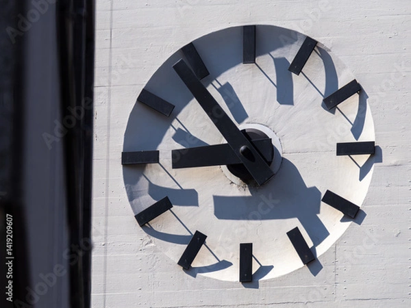 Obraz Minimalist clock with black hands and hour markers on a white wall 