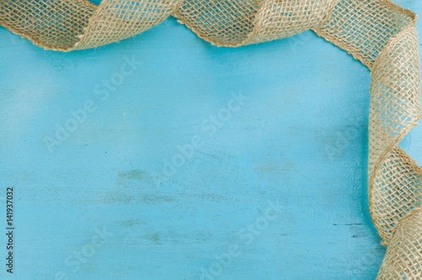 Obraz Jute ribbon  corner frame on blue wooden background with empty space