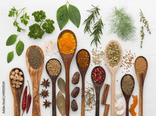 Fototapeta various kinds of spices and herbs with wood spoon on white background.