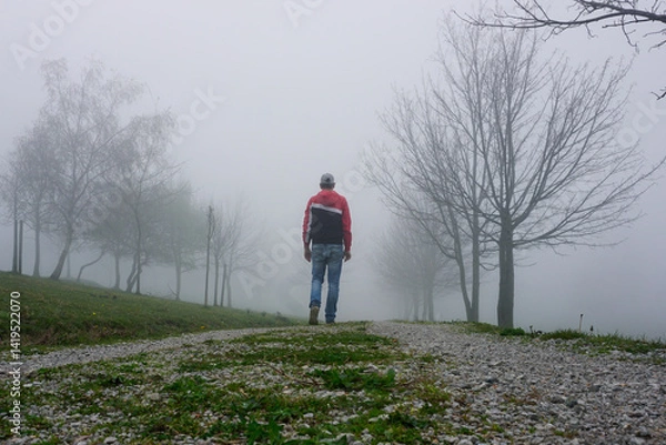 Fototapeta man trekking in the mountain with fog in winter season