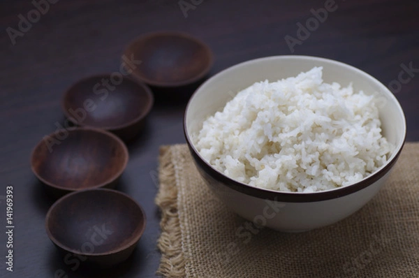 Fototapeta Thai rice in bowl with wooden empty and small bowl  on table  in dark tone