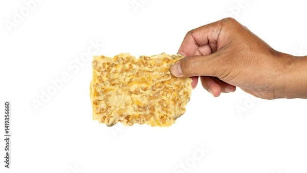 Obraz Hand holding crispy tempe chips (keripik tempe) with white background