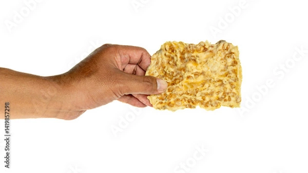 Obraz Hand holding crispy tempe chips (keripik tempe) with white background