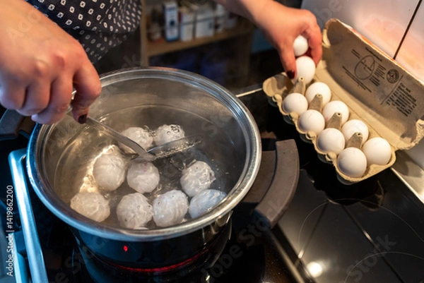 Fototapeta Eier kochen und in einen Topf mit heißem Wasser legen