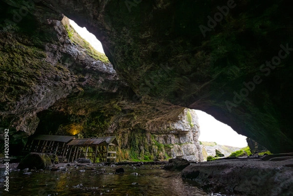 Fototapeta Smoo Cave in the Scottish Highlands captivates with its wide coastal opening and water-carved chambers. A wild and mysterious landscape, rich in natural wonder and atmosphere.
