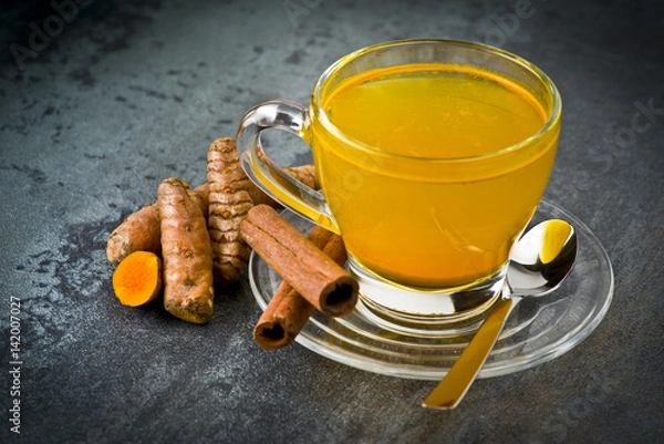 Obraz herbal tea with turmeric powder,slices and cinnamon