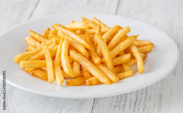 Obraz Golden fries piled high on white plate resting on rustic white table