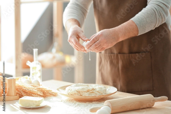 Fototapeta Man making dough in kitchen