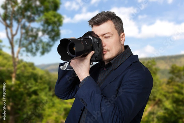 Fototapeta Photographer with photo camera takes the picture