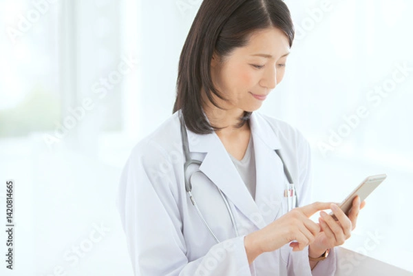 Obraz スマートフォンを操作する女性医師