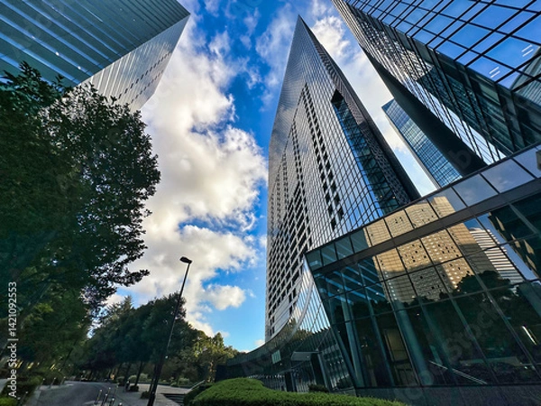 Fototapeta 都会の高層マンションと青空と白い雲と緑の植物、昼