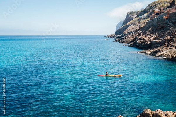 Fototapeta Paysage de Majorque aux Baléares. Mer méditerranée. Kayaking et voilier sur l'eau bleu tropicale. Littoral rocheux et côte sauvage. Loisir de vacances. Bateau de vacanciers. Canoë. Cala Clara Beach