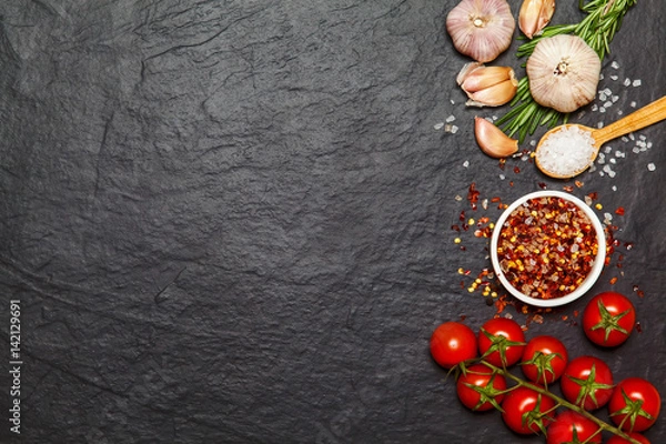 Fototapeta Colorful spices in spoons and tomatoes on dark vintage background. Top view. Food and cuisine ingredients.