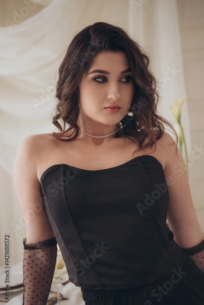 Fototapeta Beautiful woman in strapless black outfit with curly hairstyle