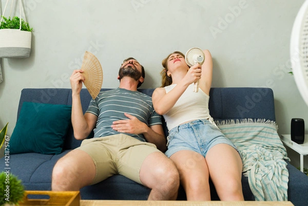 Obraz Overheated couple sweating at home during summer heat wave