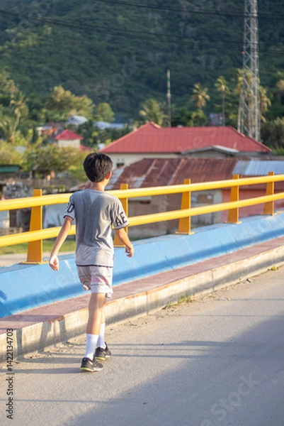 Fototapeta Boy Walking on a Scenic Bridge