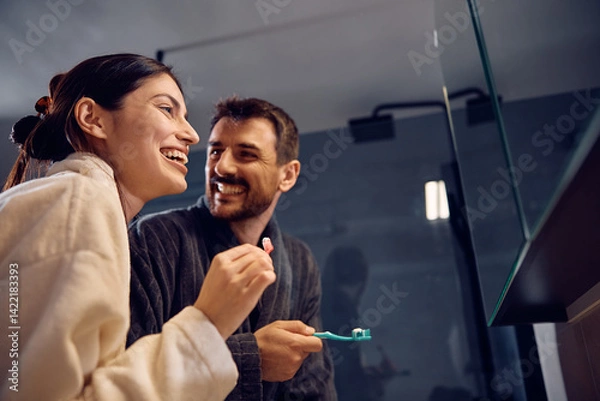Obraz Happy couple having fun while brushing their teeth in bathroom.