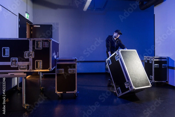 Obraz Roadie tipping over a flightcase