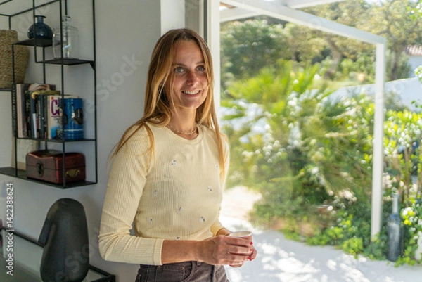 Fototapeta Woman at home feeling happy smiling, starting the day, with coffee mug on her hand. Good morning, feeling calm 