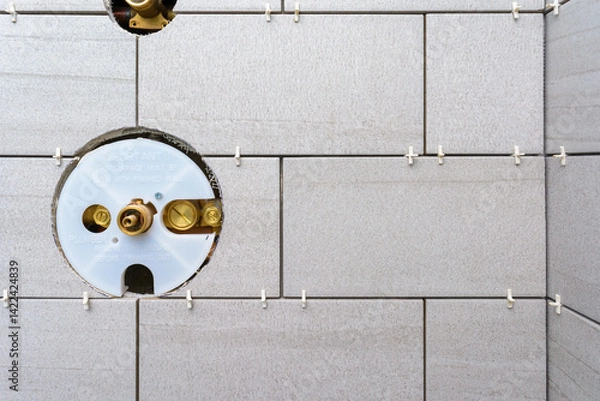 Fototapeta Corner of a shower renovation install showing tile spacers before grouting and cutout hole for the main shower fixture