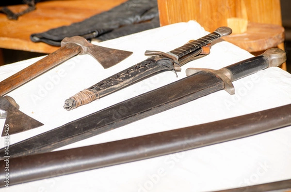 Fototapeta collection of historical axes and daggers laid out in a historical reenactment medieval event party medieval combat weapons