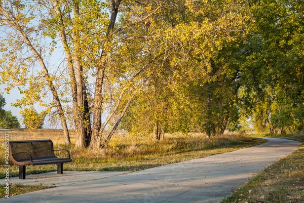 Obraz bench and recreational biking trail in Boyd Lake State Park near Loveland, Colorado, fall scenery