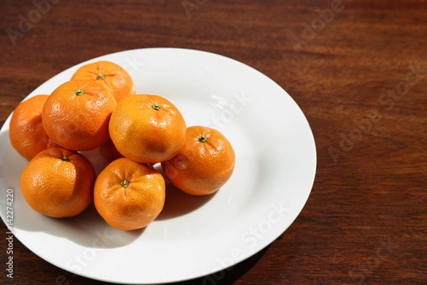 Obraz Fresh oranges on white plate in sunshine