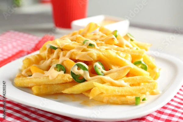 Obraz Portion of delicious french fries and cheese sauce, closeup