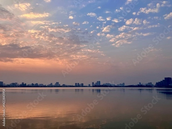 Fototapeta Tranquil Waterfront Dreamscape: Soft Clouded Sunset Reflection on West Lake in Hanoi, Vietnam